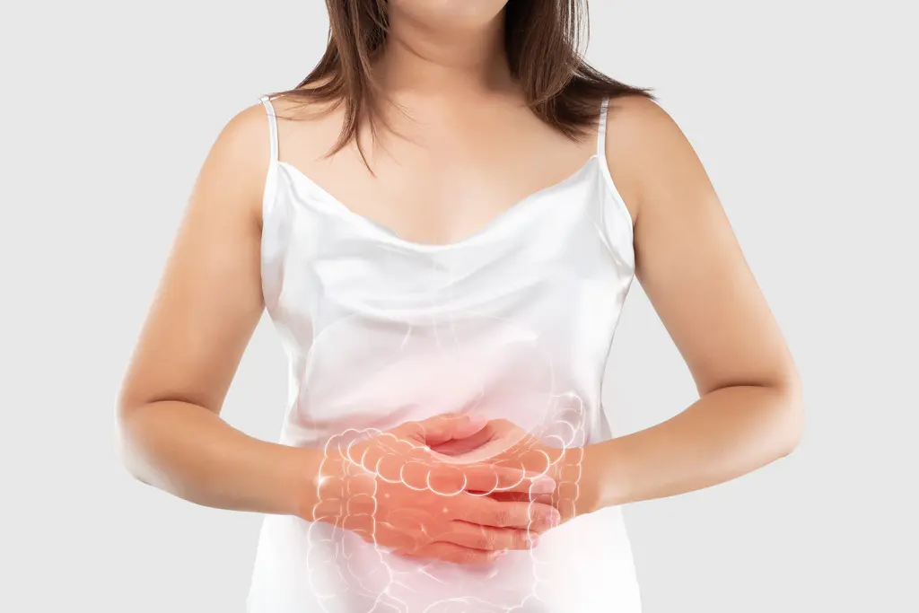 Mulher com as mãos no abdômen, simulando dor por conta de intestino inflamado